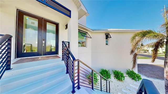 entrance to property with french doors and stucco siding