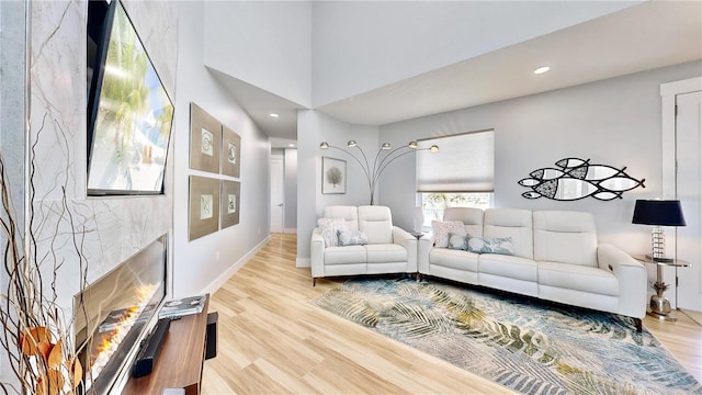 living room with recessed lighting, a fireplace, wood finished floors, and baseboards