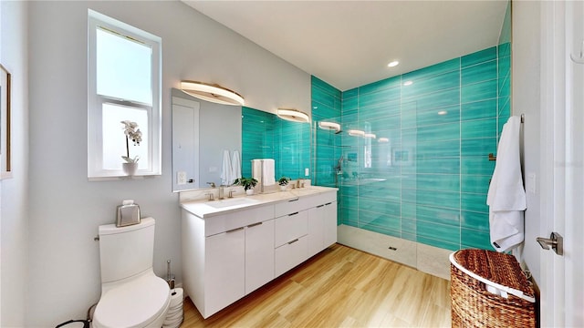 full bathroom featuring a walk in shower, toilet, a sink, wood finished floors, and double vanity