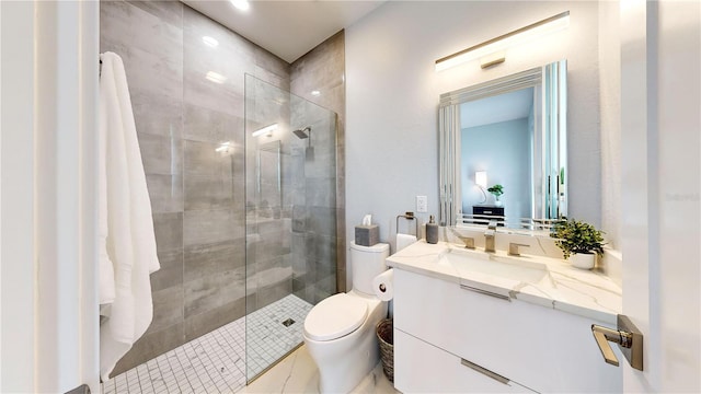 bathroom featuring tiled shower, vanity, and toilet