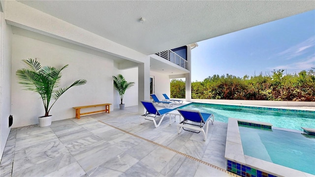 view of pool with a patio and a pool with connected hot tub