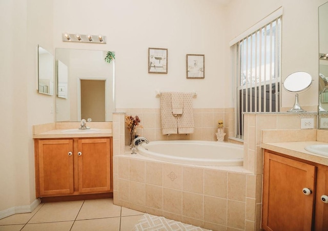 bathroom featuring vanity, tile patterned flooring, and a relaxing tiled tub