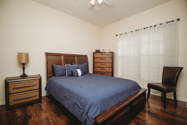 bedroom with dark hardwood / wood-style flooring and ceiling fan