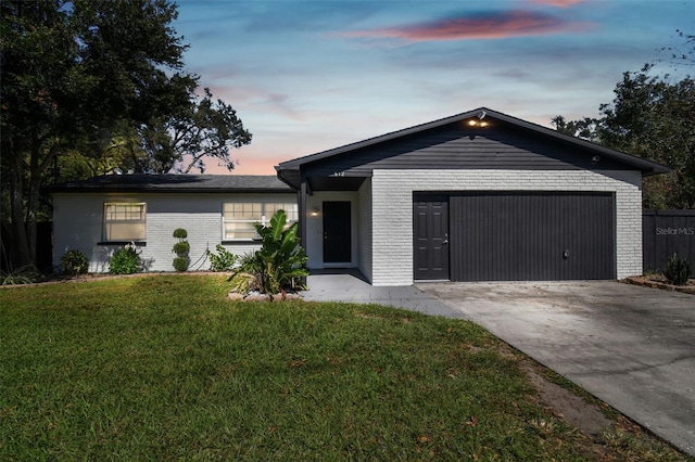 ranch-style house with a yard and a garage