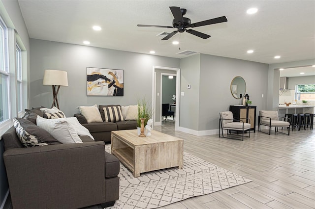 living room featuring ceiling fan and light hardwood / wood-style floors