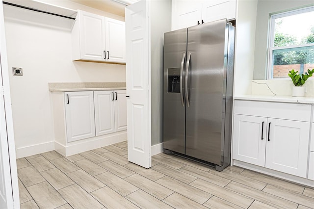 kitchen featuring white cabinets and stainless steel fridge