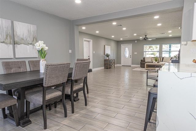 dining space featuring a textured ceiling, light hardwood / wood-style flooring, and ceiling fan