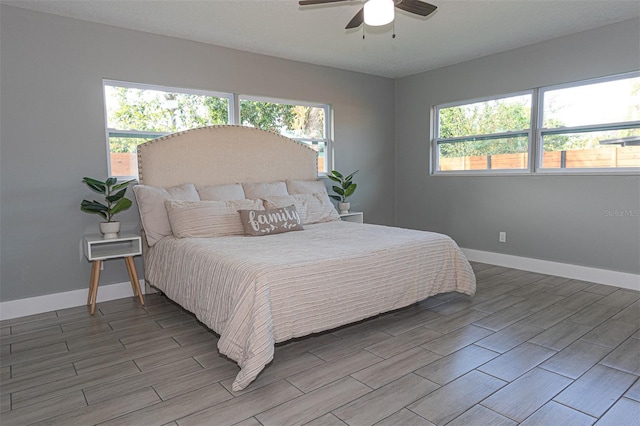 bedroom with multiple windows, ceiling fan, and hardwood / wood-style flooring