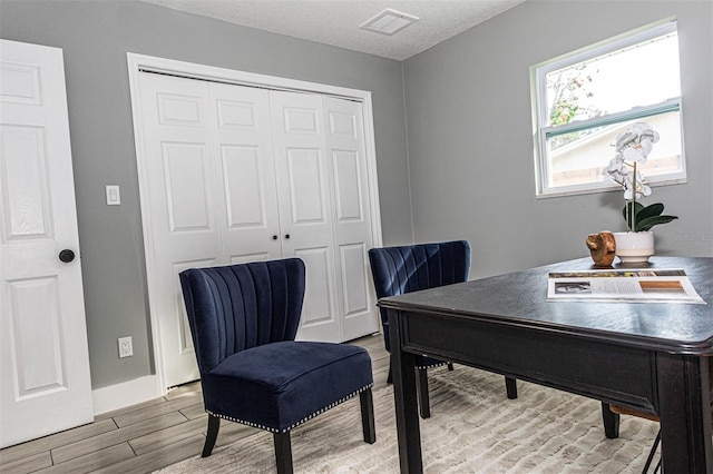 home office with hardwood / wood-style floors and a textured ceiling