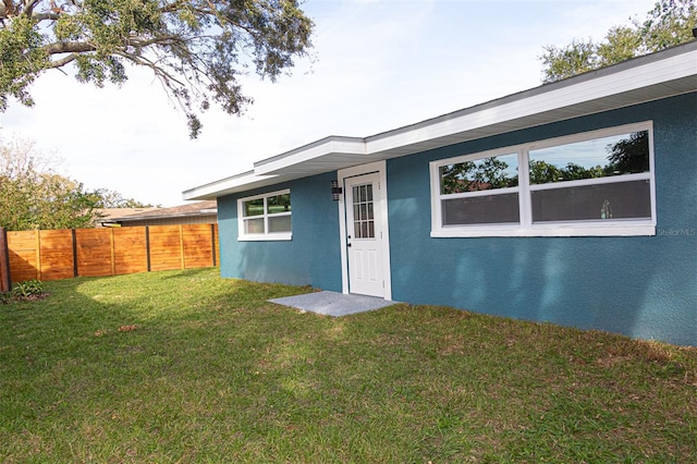 property entrance featuring a lawn