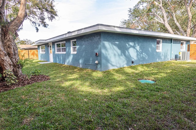 view of side of property featuring a yard and cooling unit