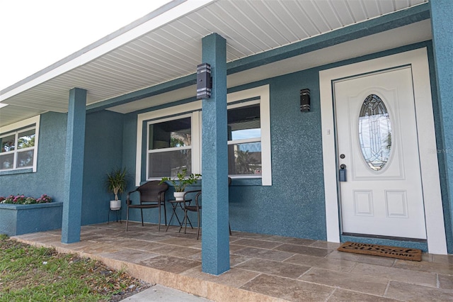 view of exterior entry with covered porch