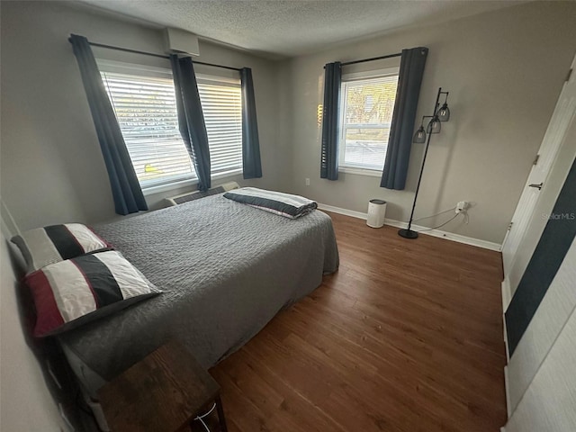 bedroom featuring a textured ceiling and dark hardwood / wood-style floors