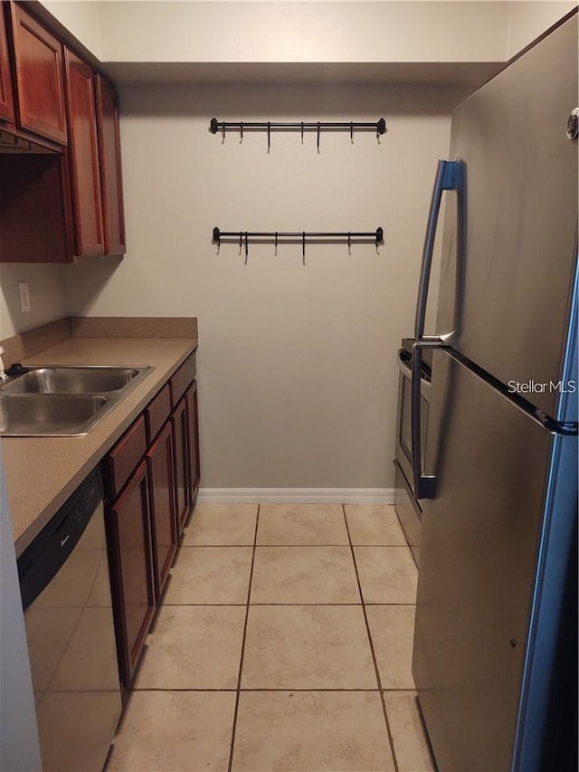 kitchen featuring sink, light tile patterned flooring, and stainless steel appliances