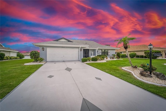 ranch-style house featuring a yard and a garage