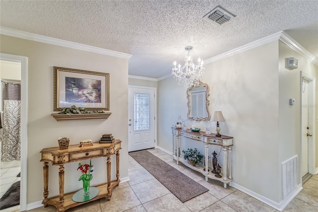 tiled foyer entrance with a textured ceiling, an inviting chandelier, and ornamental molding