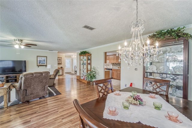 dining area with ceiling fan, light hardwood / wood-style floors, a textured ceiling, and ornamental molding