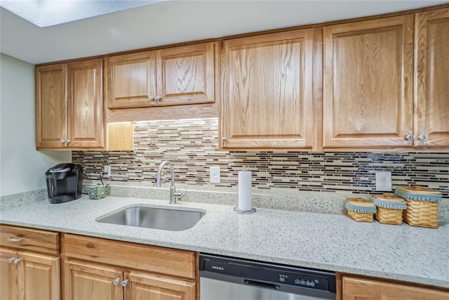 kitchen with dishwasher, decorative backsplash, light stone counters, and sink