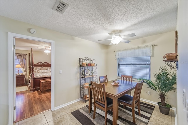 dining area featuring light tile patterned floors and a textured ceiling