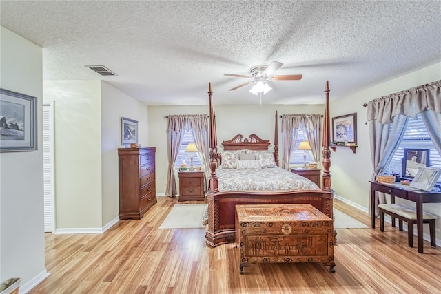 bedroom featuring a textured ceiling, light hardwood / wood-style floors, and ceiling fan