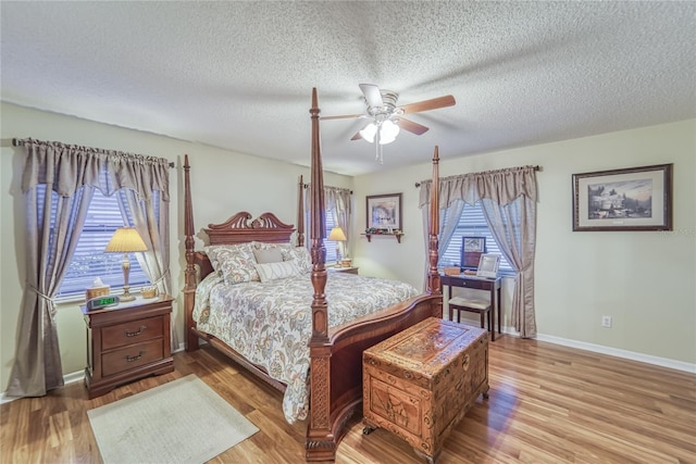 bedroom featuring ceiling fan, light wood-type flooring, and a textured ceiling