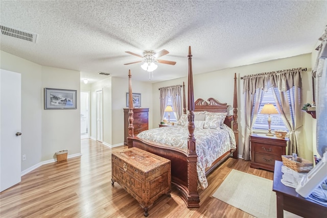 bedroom with multiple windows, ceiling fan, light hardwood / wood-style floors, and a textured ceiling