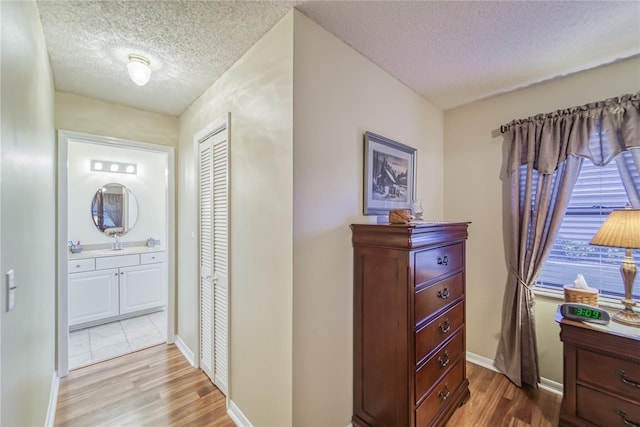 hall with hardwood / wood-style floors and a textured ceiling