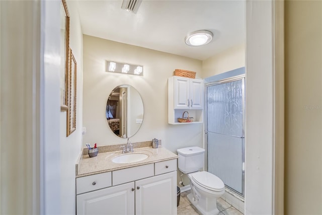 bathroom with toilet, vanity, tile patterned floors, and walk in shower