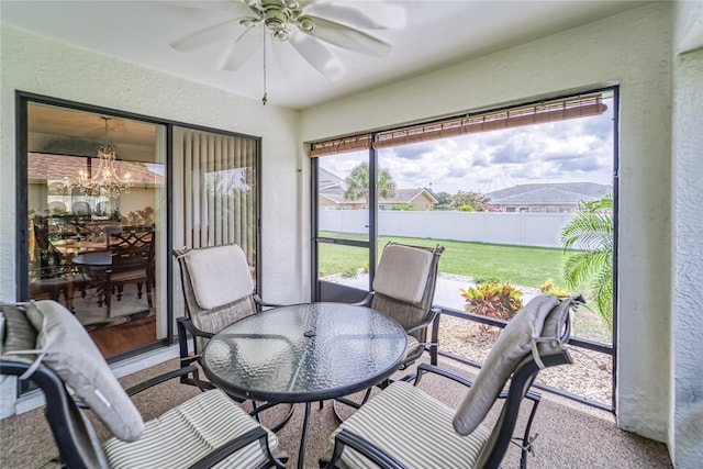 sunroom / solarium with ceiling fan with notable chandelier