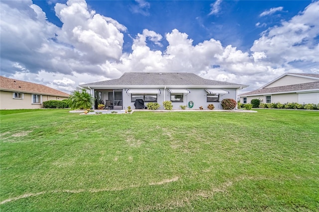 rear view of house featuring a lawn