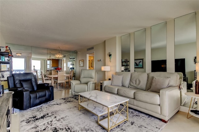 living room with a textured ceiling and an inviting chandelier