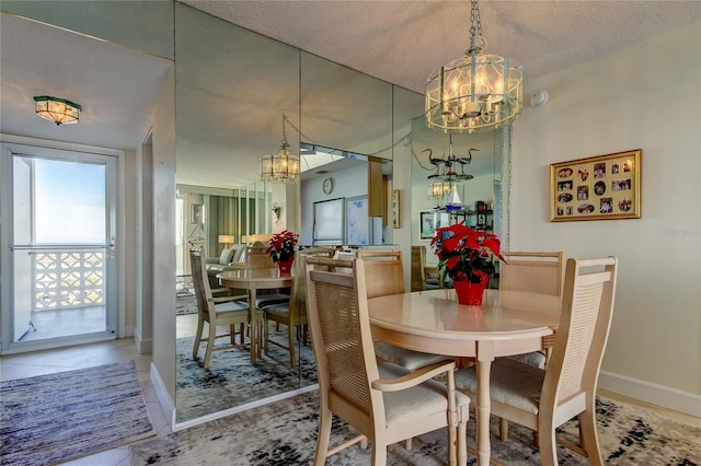 tiled dining space featuring a notable chandelier and a textured ceiling