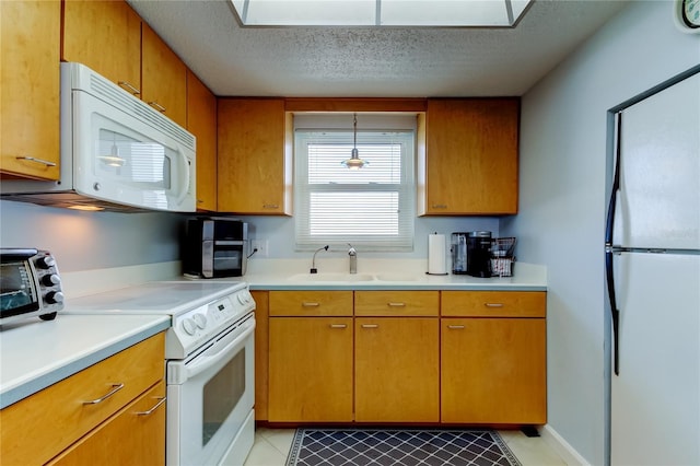 kitchen featuring sink, pendant lighting, a textured ceiling, white appliances, and light tile patterned floors