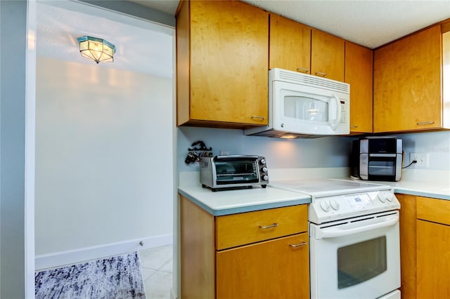 kitchen with light tile patterned flooring and white appliances