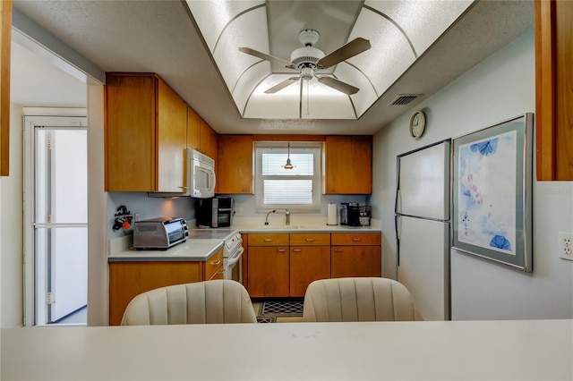 kitchen featuring white appliances, ceiling fan, and sink