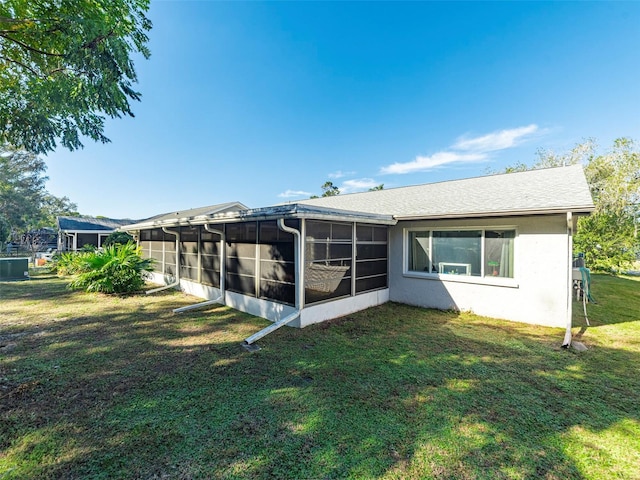 rear view of property with a yard and a sunroom