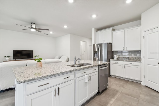 kitchen featuring white cabinets, appliances with stainless steel finishes, a center island with sink, and sink