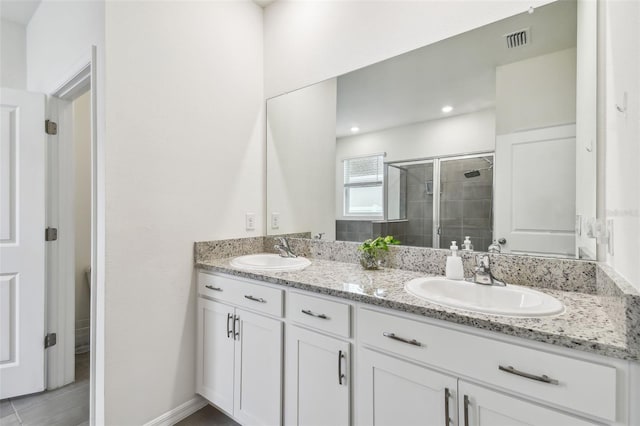 bathroom with vanity and a shower with shower door