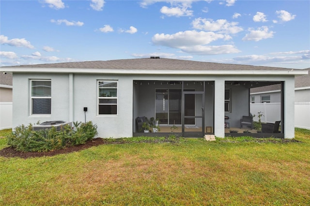 rear view of property featuring a sunroom, a yard, and central AC