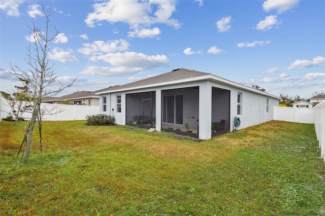 back of property with a lawn and a sunroom