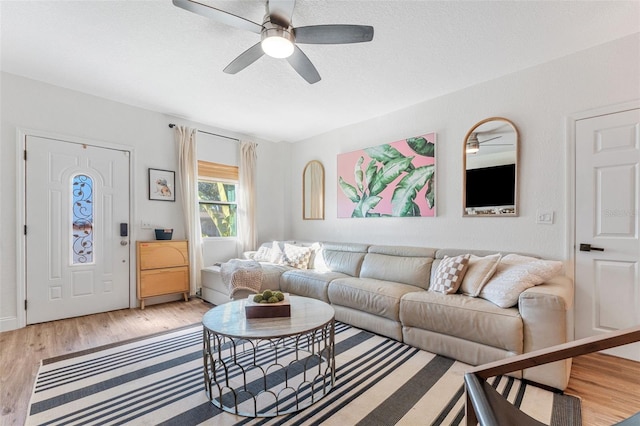 living room with light hardwood / wood-style flooring and ceiling fan