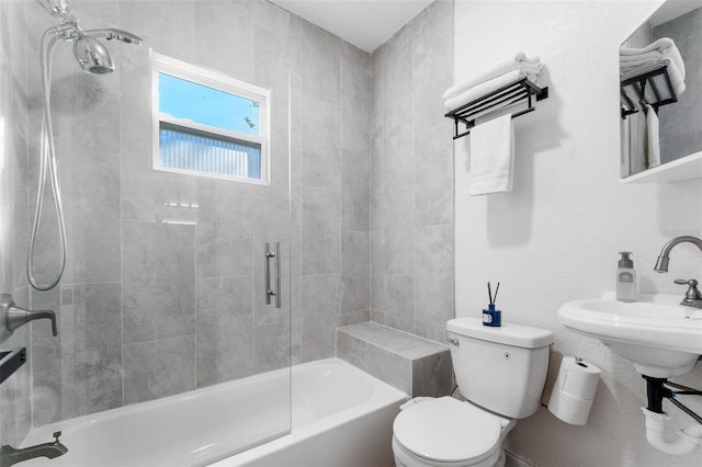 bathroom with tiled shower / bath combo and toilet