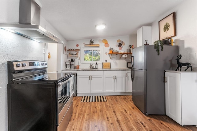 kitchen featuring sink, vaulted ceiling, wall chimney exhaust hood, white cabinetry, and stainless steel appliances