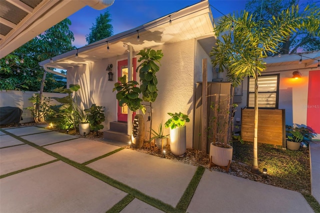 exterior entry at dusk with a patio area