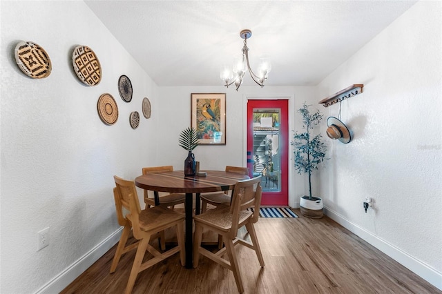 727 53rd Ter N, Saint Petersburg, FL 33703 - dining area with a chandelier, a textured wall, baseboards, and wood finished floors