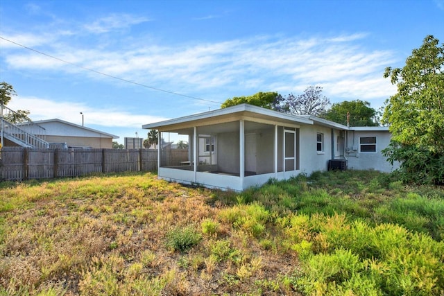 back of property featuring a sunroom and central AC