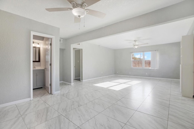 unfurnished bedroom with a closet, ensuite bath, and ceiling fan