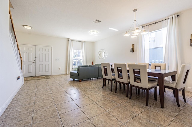 dining space with light tile patterned flooring and a chandelier