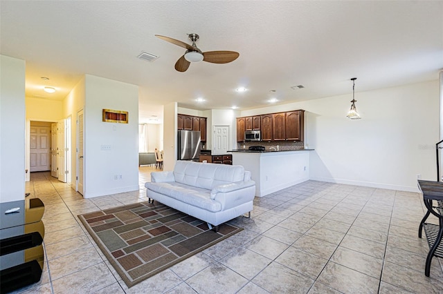 living room with light tile patterned floors, a textured ceiling, and ceiling fan