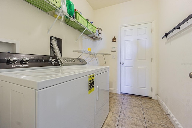 laundry room featuring a barn door, washing machine and dryer, and light tile patterned flooring